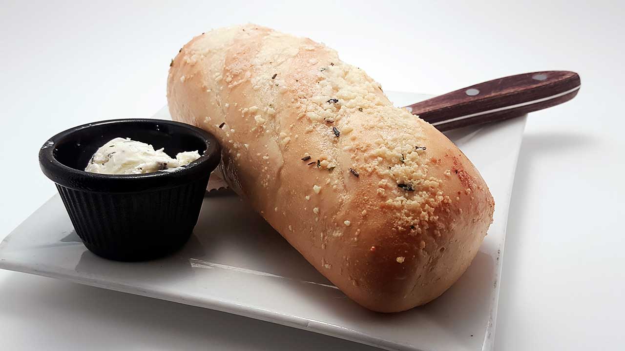 French Loaf Topped With Herb Butter And Parmesan Cheese